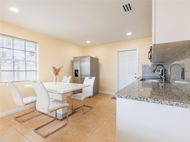 dining space featuring sink and light tile patterned flooring