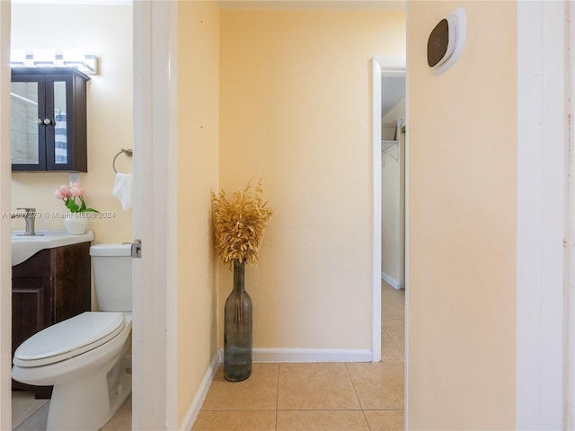 bathroom with toilet, vanity, and tile patterned floors