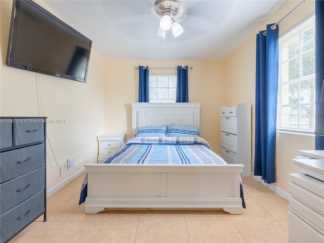 tiled bedroom featuring multiple windows and ceiling fan