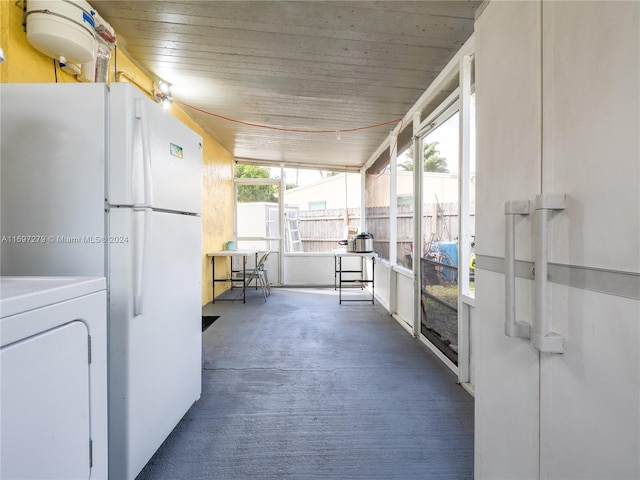 unfurnished sunroom featuring a healthy amount of sunlight and washer / dryer