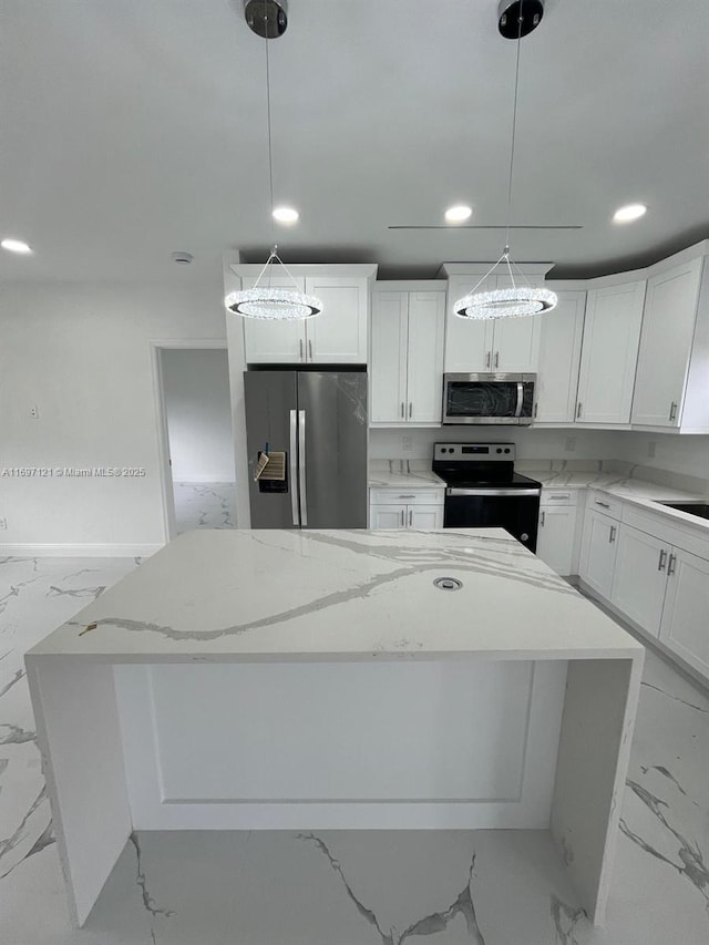 kitchen with light stone countertops, stainless steel appliances, pendant lighting, white cabinets, and a kitchen island