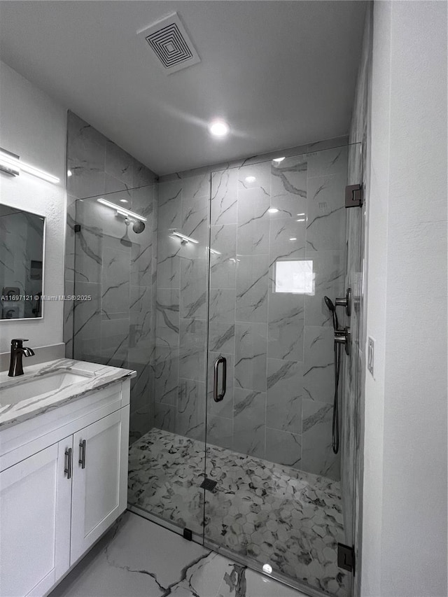 bathroom with vanity and a shower with shower door