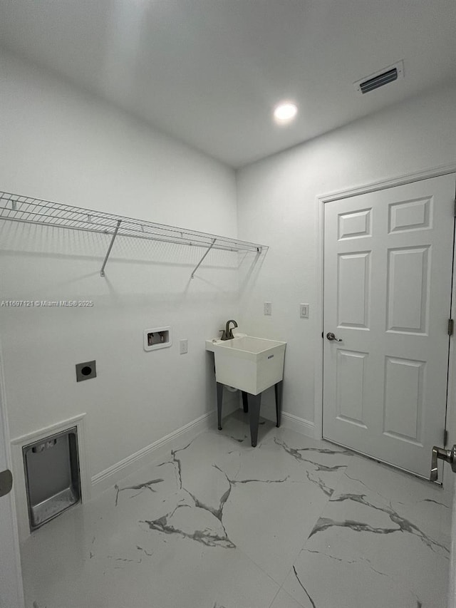 laundry area with hookup for an electric dryer, hookup for a washing machine, and sink