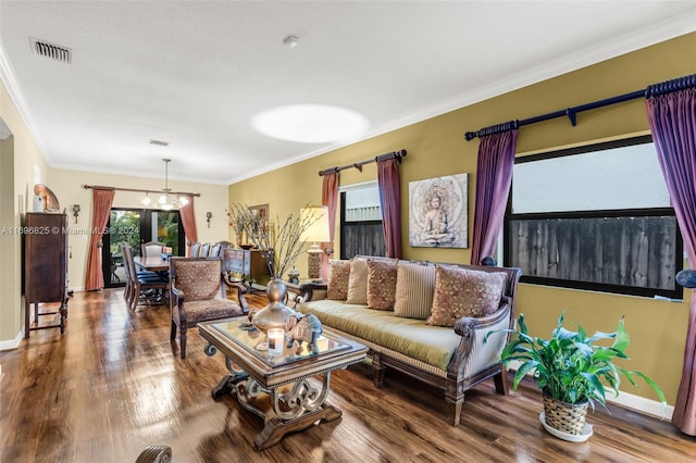 living room featuring hardwood / wood-style floors, a notable chandelier, and crown molding