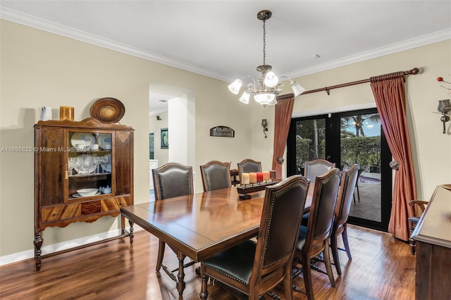 dining room with dark hardwood / wood-style floors, an inviting chandelier, crown molding, and french doors