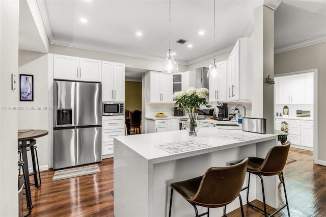 kitchen with appliances with stainless steel finishes, tasteful backsplash, ornamental molding, white cabinets, and dark hardwood / wood-style floors