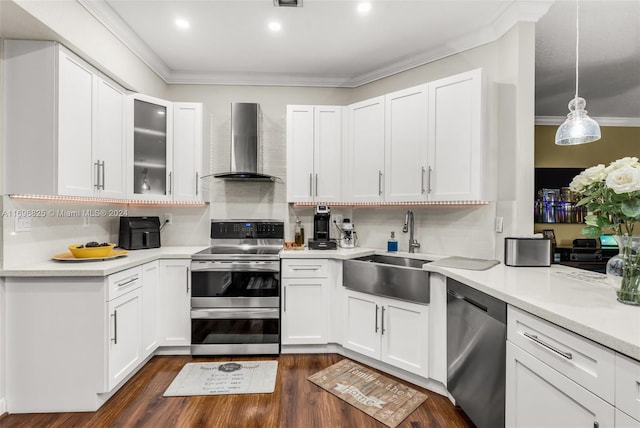 kitchen featuring stainless steel appliances, white cabinetry, and wall chimney range hood