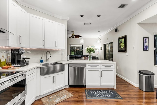 kitchen featuring sink, ceiling fan, dark hardwood / wood-style floors, appliances with stainless steel finishes, and kitchen peninsula