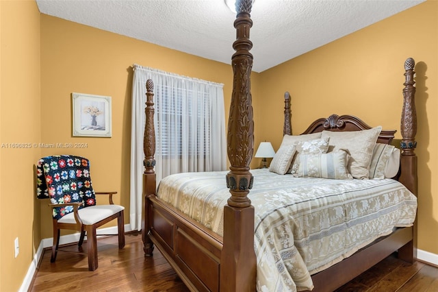 bedroom with dark hardwood / wood-style flooring and a textured ceiling