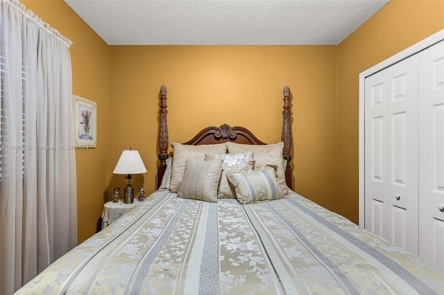 bedroom with a textured ceiling and a closet