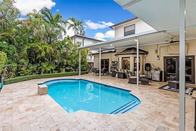 view of pool with outdoor lounge area, ceiling fan, and a patio area