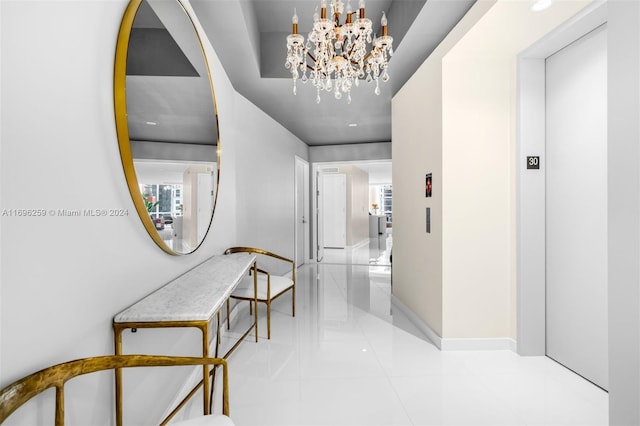 hall featuring light tile patterned flooring, elevator, and an inviting chandelier