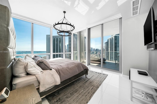 tiled bedroom with multiple windows, a water view, a chandelier, and access to exterior