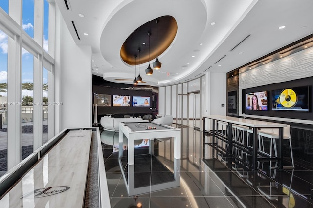 interior space with tile patterned flooring and a raised ceiling