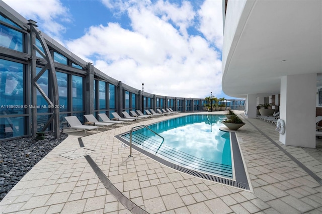 view of swimming pool featuring a lanai and a patio area