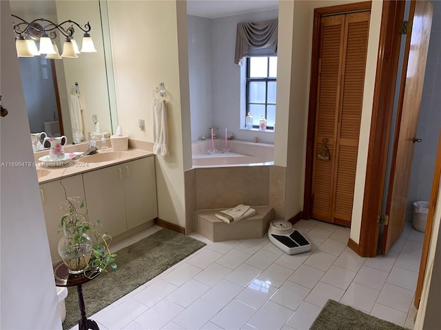 bathroom featuring tile patterned flooring, vanity, and a tub to relax in