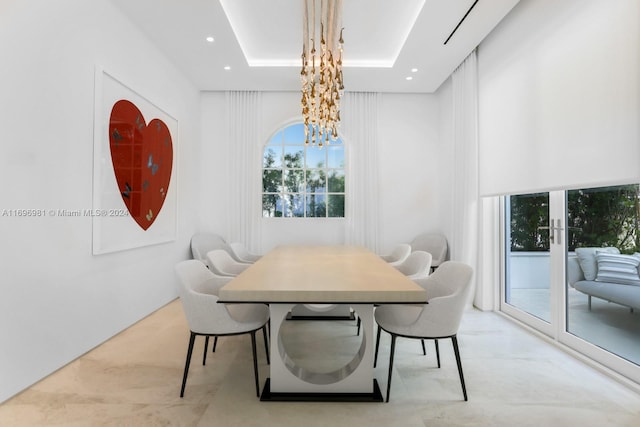 dining space featuring a tray ceiling and a chandelier