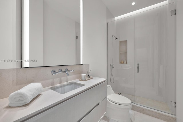 bathroom featuring vanity, toilet, a shower with shower door, and backsplash