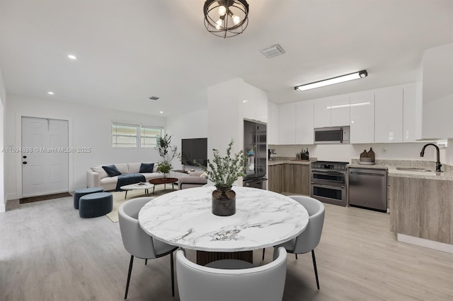 dining area with sink and light hardwood / wood-style flooring