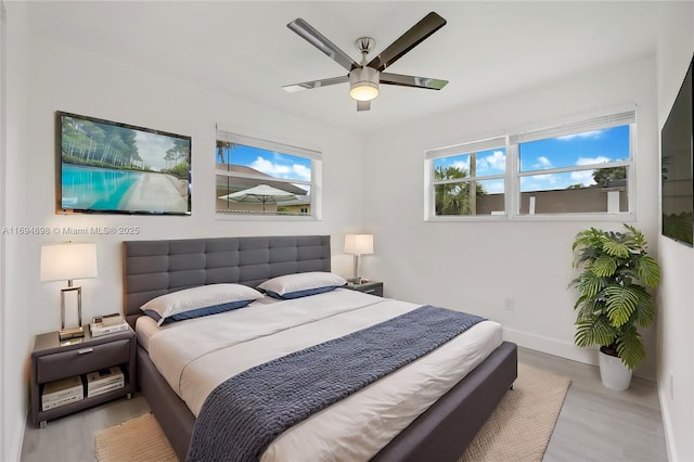 bedroom featuring ceiling fan, light hardwood / wood-style flooring, and a closet