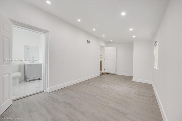 unfurnished bedroom featuring ceiling fan, two closets, and light wood-type flooring