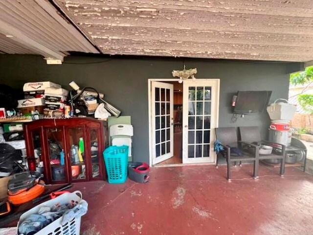 exterior space with concrete flooring, french doors, and a chandelier