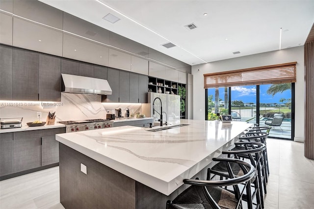 kitchen featuring a breakfast bar, a spacious island, and range hood