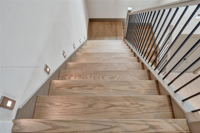 staircase with hardwood / wood-style flooring