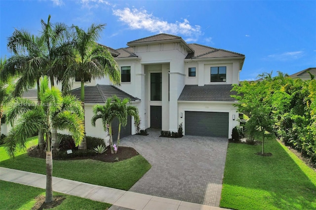 mediterranean / spanish-style house featuring a garage and a front lawn