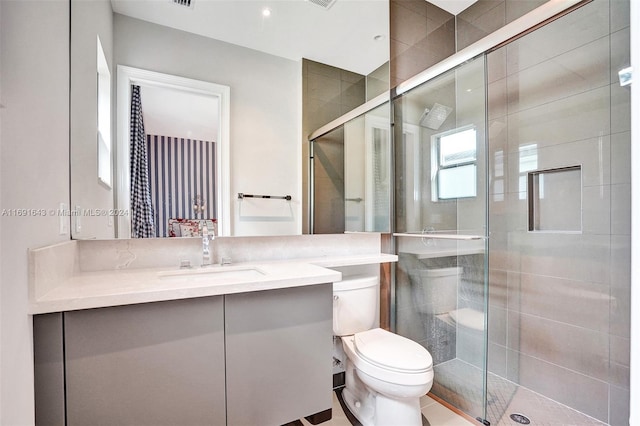 bathroom featuring tile patterned flooring, vanity, an enclosed shower, and toilet