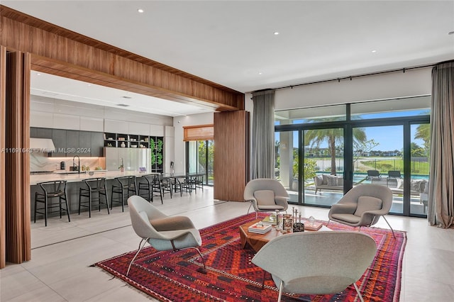 living room with light tile patterned flooring, a healthy amount of sunlight, and sink