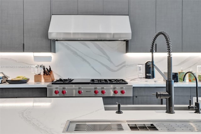 interior details featuring gray cabinets, light stone counters, and ventilation hood