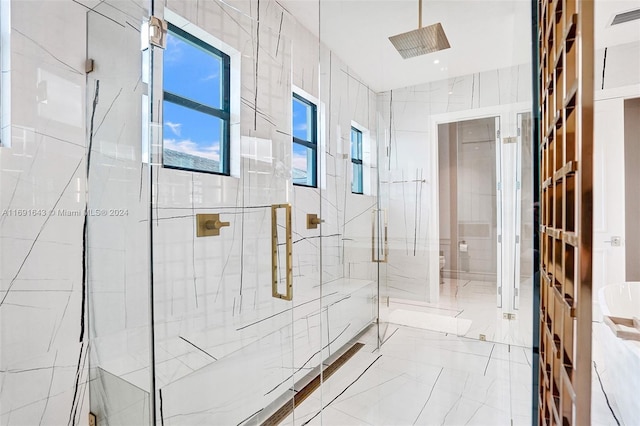 bathroom featuring a shower with shower door and tile walls