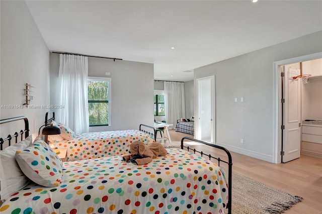 bedroom featuring a closet, a spacious closet, and light hardwood / wood-style flooring