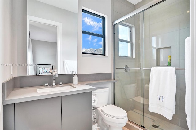 bathroom with vanity, toilet, and a shower with shower door