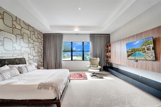 bedroom with carpet floors and a tray ceiling