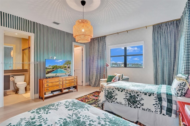 bedroom featuring ensuite bathroom and light hardwood / wood-style floors