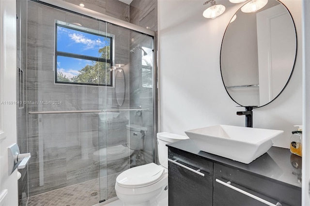 bathroom featuring an enclosed shower, vanity, and toilet