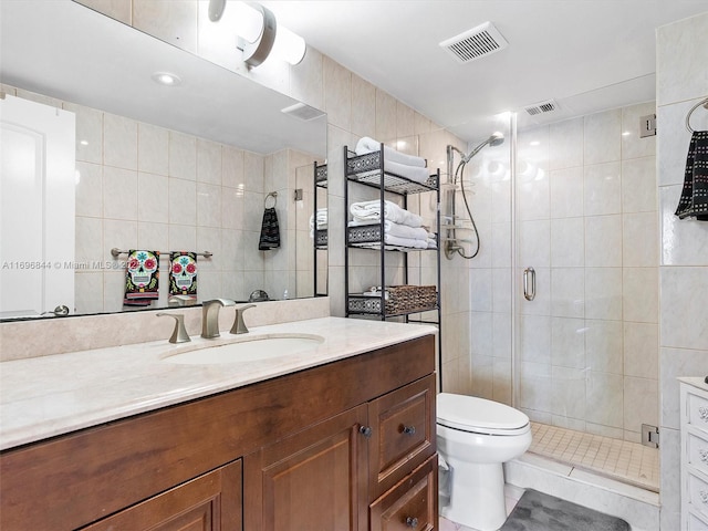 bathroom with tile walls, vanity, and a shower with shower door