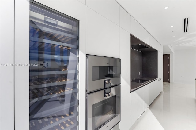 kitchen with wine cooler, white cabinetry, black electric cooktop, and stainless steel oven