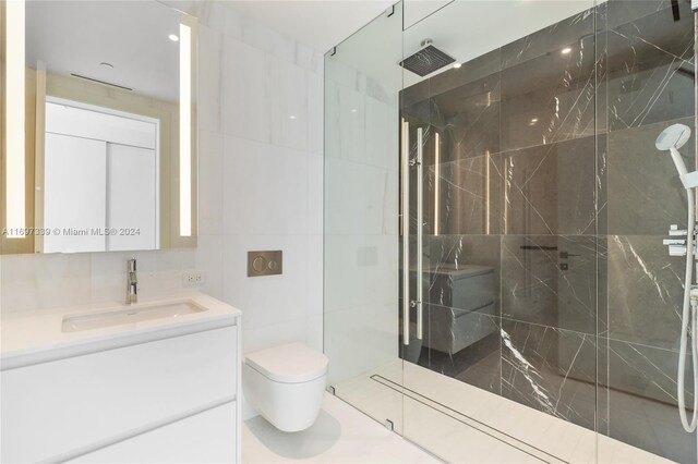 bathroom with vanity, toilet, tiled shower, tile walls, and tasteful backsplash