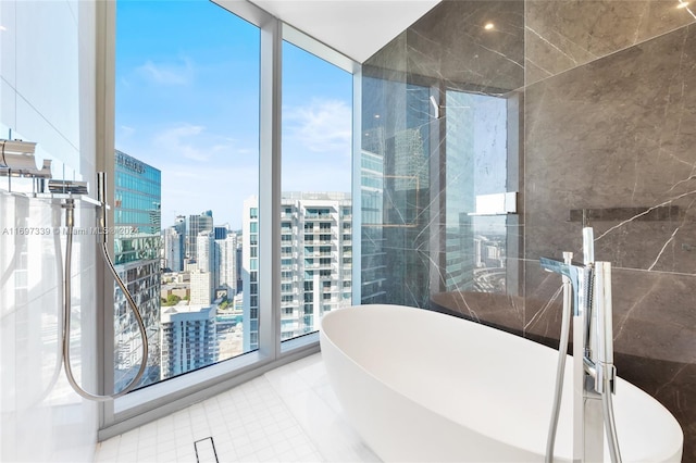 bathroom with a tub, tile patterned flooring, and floor to ceiling windows