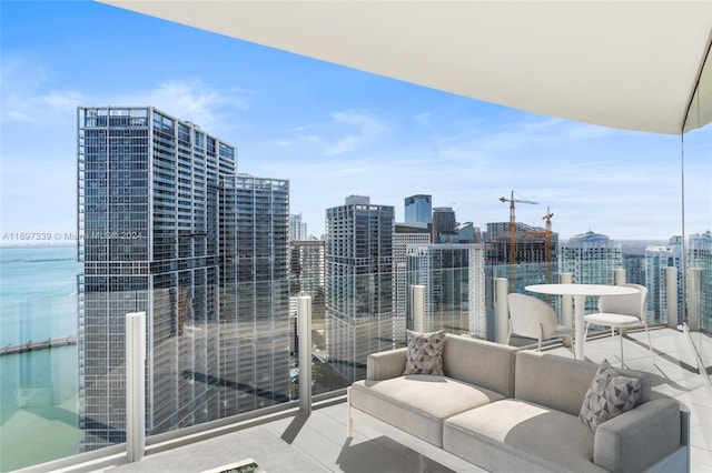 balcony with an outdoor living space and a water view