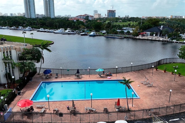 view of swimming pool with a patio and a water view