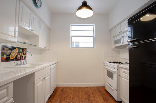 kitchen featuring white cabinets, white appliances, and tasteful backsplash