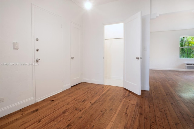 empty room with hardwood / wood-style flooring and a wall mounted air conditioner