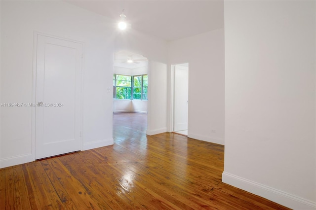 empty room with hardwood / wood-style floors and ceiling fan