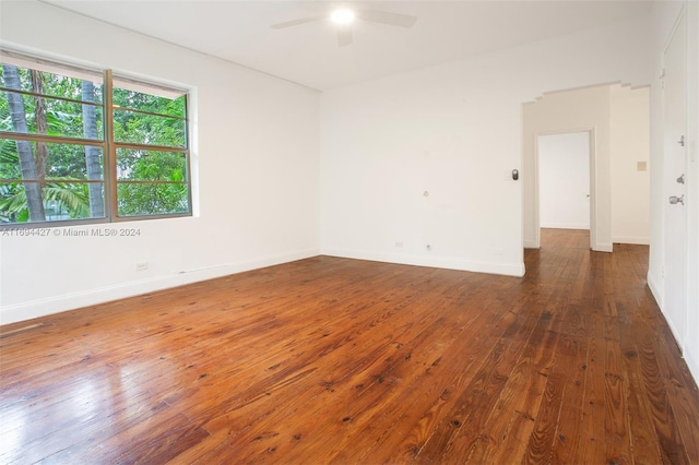 unfurnished room featuring ceiling fan and dark wood-type flooring