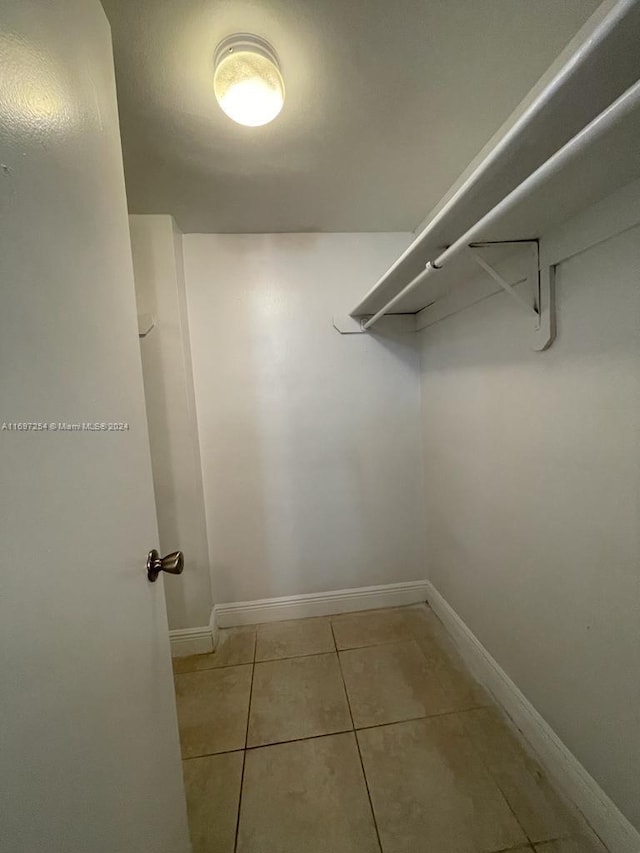 spacious closet with light tile patterned floors