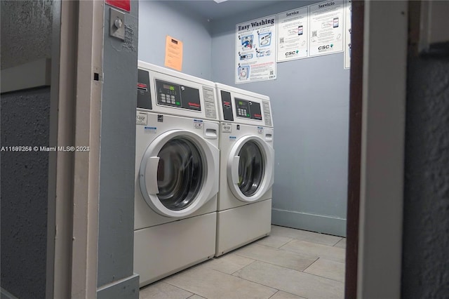 laundry area with light tile patterned flooring and washing machine and dryer